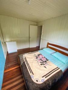 een slaapkamer met een bed met een deken erop bij Casa d campo, pátio amplo, cercado. 5min do centro in Rolante