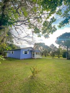 una casa azul en medio de un campo en Casa d campo, pátio amplo, cercado. 5min do centro en Rolante