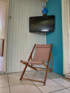 mecedora de madera en una habitación con TV en Casa d campo, pátio amplo, cercado. 5min do centro en Rolante