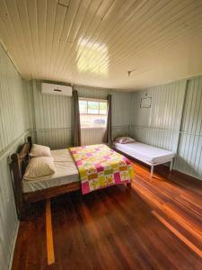 een kleine slaapkamer met een bed en een raam bij Casa d campo, pátio amplo, cercado. 5min do centro in Rolante