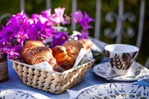 uma cesta de pão e uma chávena de café numa mesa em Le Maschere B&B em Santa Teresa Gallura
