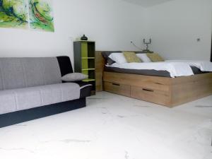 1 dormitorio con 1 cama y 1 sofá en TOMO 2, en Postojna