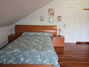 a bedroom with a bed and a wooden head board at La Casuca de Trasmiera en Arnuero in Arnuero