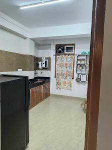 a kitchen with a black refrigerator and wooden cabinets at Natures Life urban homestay in Gangtok