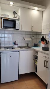 a kitchen with white cabinets and a microwave at Ihr Bett mit Blick auf die Weinberge in Bad Dürkheim