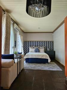 a bedroom with a bed and a couch and a chandelier at iShoba Retreat in Centurion