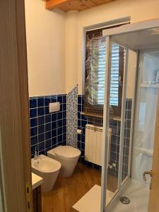 een blauw betegelde badkamer met een toilet en een wastafel bij Casa “il riposo del pescatore” in Porto San Giorgio