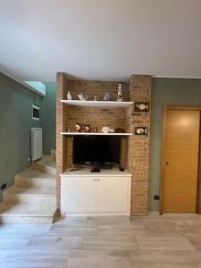 a living room with a tv and a staircase at Casa “il riposo del pescatore” in Porto San Giorgio