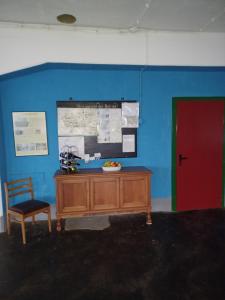 eine blaue Wand mit einem Schreibtisch und einer roten Tür in der Unterkunft LoftCamp Großmann in Alter Graben