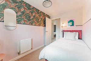 1 dormitorio con 1 cama y un mural en la pared en Stylish & Spacious 3bed Home with Fast Wifi & Private Parking, en Cambourne