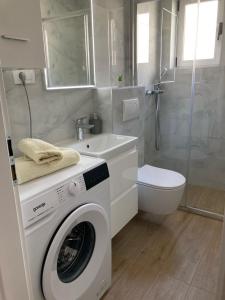 a bathroom with a washing machine and a toilet at Studio Apartment 3e in Split