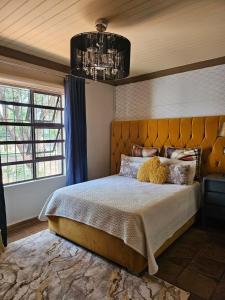 a bedroom with a large bed and a chandelier at iShoba Retreat in Centurion