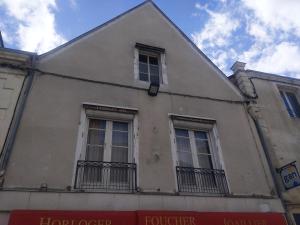un edificio con dos ventanas laterales en Logis de la Grande Rue, appt cœur de ville, spacieux, lumineux, parquet 3 chbres, - 6 pers, en La Flèche