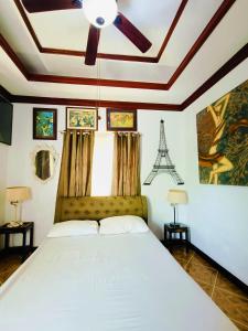 sypialnia z łóżkiem i wentylatorem sufitowym w obiekcie Negros Haven Seaside Resort w mieście Jayugan