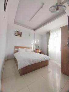een slaapkamer met een groot bed en een raam bij Trưởng Sky Hotel Đà Lạt in Da Lat