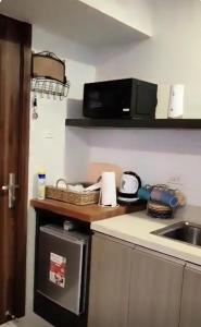 een keuken met een aanrecht met een wastafel en een magnetron bij HORIZONS 101 TOWER 2 (30-S) in Cebu City