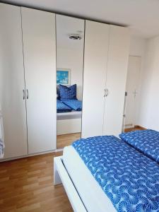 a bedroom with white cabinets and a blue bed at Panorama Apart Bad Säckingen in Bad Säckingen