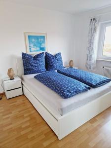 uma cama com almofadas azuis num quarto em Panorama Apart Bad Säckingen em Bad Säckingen