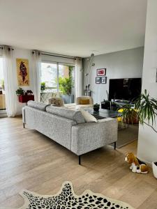soggiorno con divano e cane steso sul pavimento di chez Nathalie a Boulogne-Billancourt