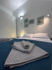San Giorgio di Piano的住宿－La Casa di Leo Apartments，一间卧室配有带毛巾的床