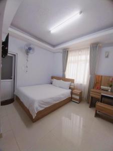 Habitación blanca con cama y escritorio en Trưởng Sky Hotel Đà Lạt, en Da Lat