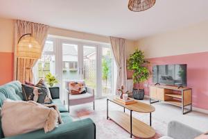 a living room with a couch and a tv at Stylish & Spacious 3bed Home with Fast Wifi & Private Parking in Cambourne