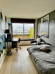 una camera con letto, scrivania e finestra di chez Nathalie a Boulogne-Billancourt