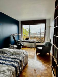 una camera con letto, sedia e scrivania di chez Nathalie a Boulogne-Billancourt