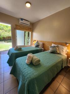 1 dormitorio con 2 camas con sábanas verdes en Casa Aqua hotel boutique en Mendoza