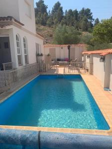 a large blue swimming pool in front of a house at Quesa Valencia Spain. in Quesa