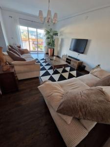 a living room with a couch and a tv at Quesa Valencia Spain. in Quesa