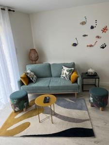 a living room with a blue couch and a table at Ty Cairn classé 3 étoiles in Paimpol