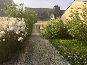 a garden with white flowers in front of a house at Ty Cairn classé 3 étoiles in Paimpol