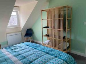 a bedroom with a bed and a book shelf at Ty Cairn classé 3 étoiles in Paimpol