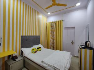 een slaapkamer met een bed met gele en witte strepen bij Yellow Inn Guest House in Lucknow