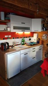 a kitchen with white cabinets and a sink at Petite Noel in Güssing