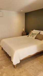 1 dormitorio con 1 cama blanca grande en una habitación en Gîte La Genestière au milieu des vignes, piscine partagée, en Mazan