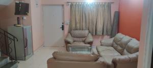 ein Wohnzimmer mit einem Sofa und 2 Stühlen in der Unterkunft Arpan Home Stay in kolkata
