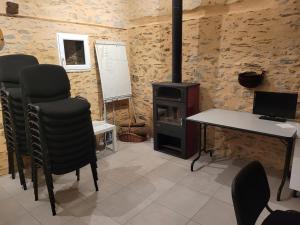 a room with a stove and a table and chairs at Gite le Nid de l'Erdre in La Pouëze