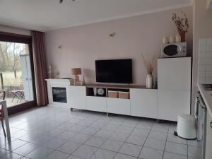 a living room with a tv and a white cabinet at 4-persoons appartement met een mooi uitzicht in De Panne
