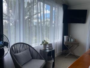 a living room with a chair and a large window at Bavaria Boutique Hotel in Auckland