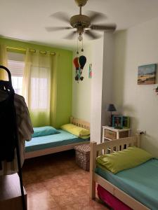 1 Schlafzimmer mit 2 Betten und einem Deckenventilator in der Unterkunft Las Gaviotas in San Juan de los Terreros
