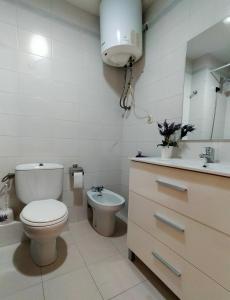 Baño blanco con aseo y lavamanos en Apartamento Plaza Ballo en Bohí