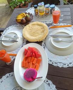 einen Tisch mit Teller mit Lebensmitteln und Obst darauf in der Unterkunft Ilasan cottage. in Tomohon + 29 Fotos