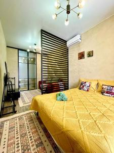 ein Schlafzimmer mit einem großen gelben Bett in einem Zimmer in der Unterkunft Брутальная квартира ЖK Sport Sity LUX in Astana