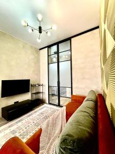 ein Wohnzimmer mit Sofa und Flachbildfernseher in der Unterkunft Брутальная квартира ЖK Sport Sity LUX in Astana