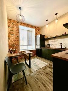 eine Küche mit einem Tisch und einem Stuhl darin in der Unterkunft Брутальная квартира ЖK Sport Sity LUX in Astana