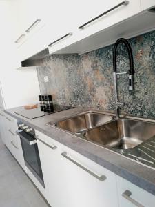un fregadero de acero inoxidable en una cocina blanca en Casa del Cigno, en Monterotondo