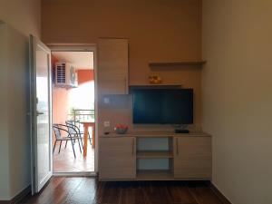 sala de estar con TV en un soporte con escritorio en Apartment Dora, en Gornji Karin