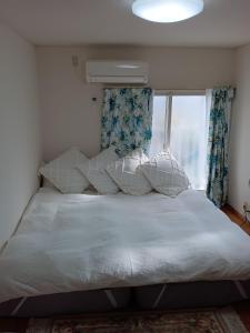 1 dormitorio con cama con almohadas y ventana en Tokyo downtown牡丹莊, en Tokio
